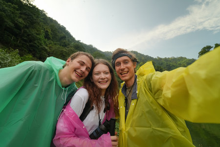Smiling young people enjoying hiking at nature and talking outdoor. young people Hiking On Mountain And Enjoys Nature.の写真素材
