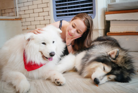 Beautiful young woman playing with a puppy. woman relaxing on floor with dog lying next to her