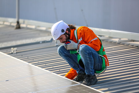 professional technician or engineer installing solar panels, Alternative energy for installed solar panels in use on roof of homeの写真素材