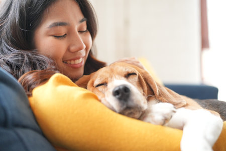 Furry friends. woman resting with dog on sofa at homeの写真素材