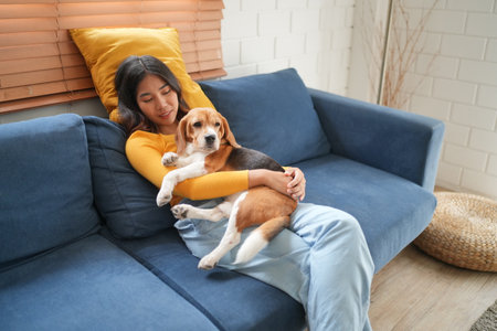 Furry friends. woman resting with dog on sofa at homeの写真素材