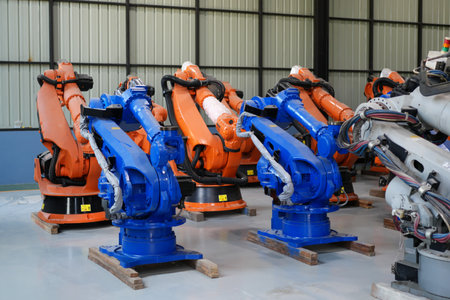 Robotics engineer working on maintenance of robotic arm in factory warehouse. Business technology.