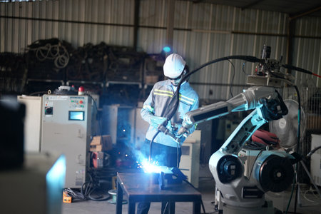 Robotics engineer working on maintenance of robotic arm in factory warehouse. Business technology.の写真素材