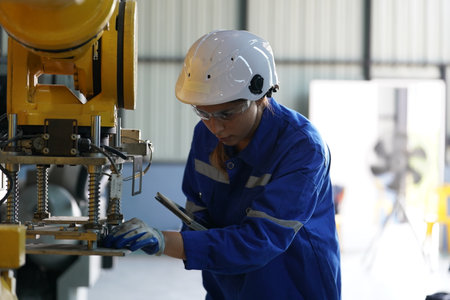 Robotics engineer working on maintenance of robotic arm in factory warehouse. Business technology.
