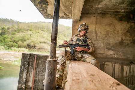 Soldier with a machine gun on the background of a concrete bridge