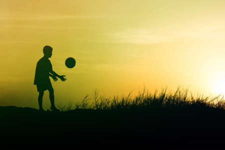 children playing ball on meadow, sunset, summertimeの写真素材