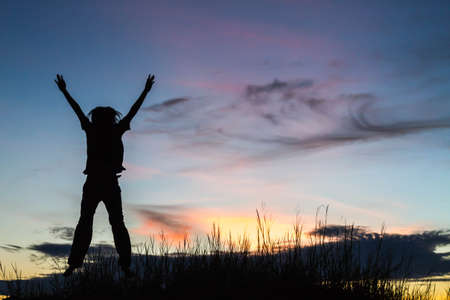 Silhouette of a beautiful girl jumpingの写真素材