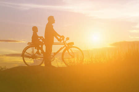 silhouette of couple driving bike happy time sunsetの写真素材