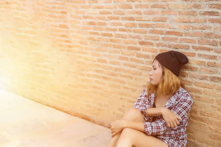Outdoor portrait of a sad teenage girl looking thoughtful about troubles in front of a gray wallの写真素材