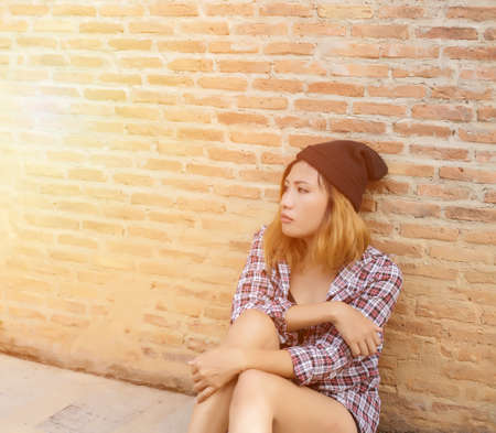 Outdoor portrait of a sad teenage girl looking thoughtful about troubles in front of a gray wallの写真素材