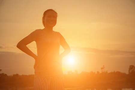silhouette young woman at sunsetの写真素材