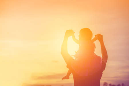Father took the baby learn to walk at sunset.の写真素材
