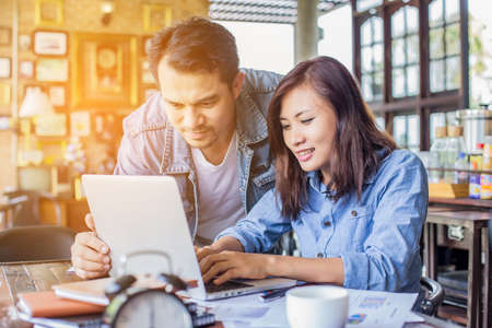 Young woman sitting in a cafe with her laptop, Stressful for work.の写真素材