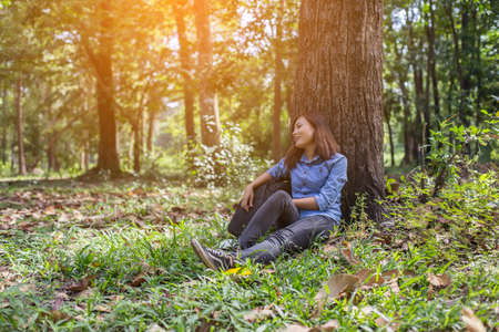 Women hiker with backpack checks map to find directions in wilderness areaの写真素材