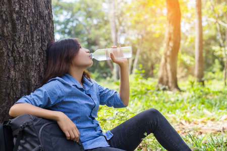 Beautiful young woman drinking water in the morning after finished joggingの写真素材