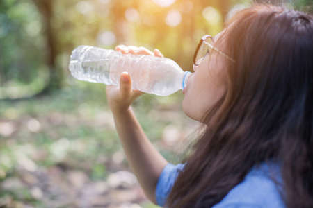 Beautiful young woman drinking water in the morning after finished jogging