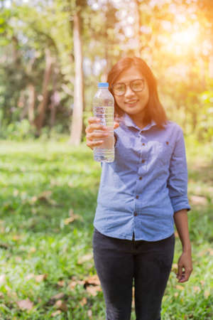 Beautiful young woman drinking water in the morning after finished joggingの写真素材