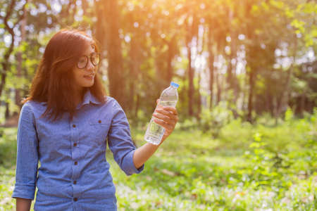 Beautiful young woman drinking water in the morning after finished joggingの写真素材