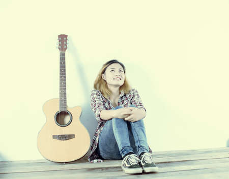 Hipster woman style portrait enjoy with guitar look so happy.の写真素材