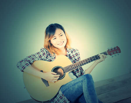 Hipster woman style portrait enjoy with guitar look so happy.の写真素材