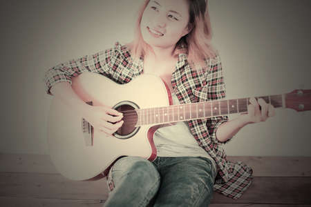 Hipster woman style portrait enjoy with guitar look so happy.の写真素材