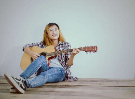Hipster woman style portrait enjoy with guitar look so happy.