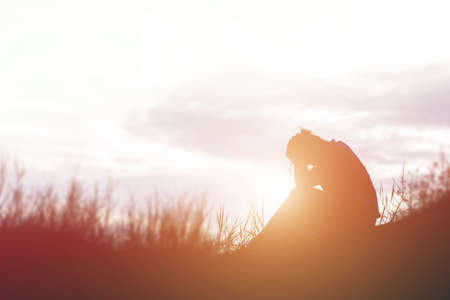 Sad and depressed woman sitting aloneの写真素材