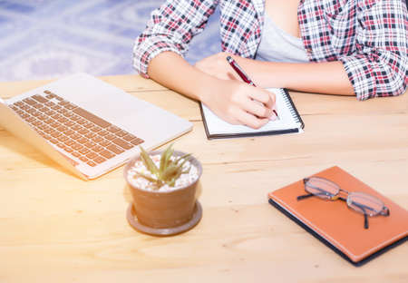 business woman writing something on notepad in office.の写真素材