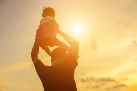 Father took the baby learn to walk at sunset.の写真素材