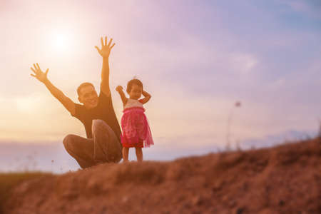 Father took the baby learn to walk at sunset.の写真素材