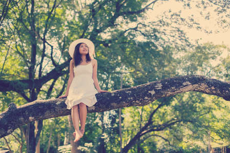 Young teen girl sitting on tree の写真素材