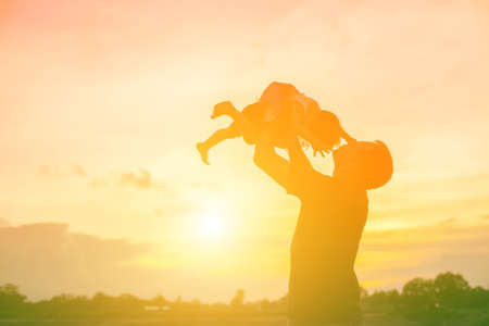 Father took the baby learn to walk at sunset.の写真素材