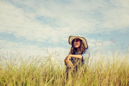 Sad young girl sitting alone on a grass outdoors,Sadness. Loneliness