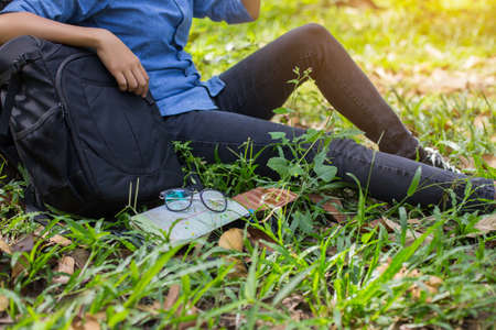 Women hiker with backpack checks map to find directions in wilderness areaの写真素材