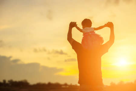Father took the baby learn to walk at sunset.の写真素材