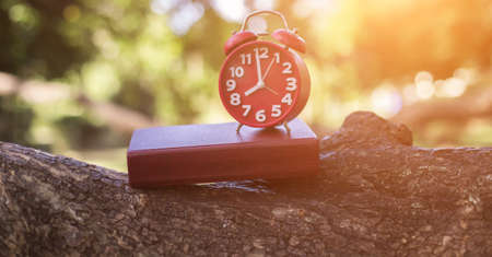 retro clock time at 8 o'clock with notebook or memo on wood table, times of memory writing diary concept vintage color tone.の写真素材