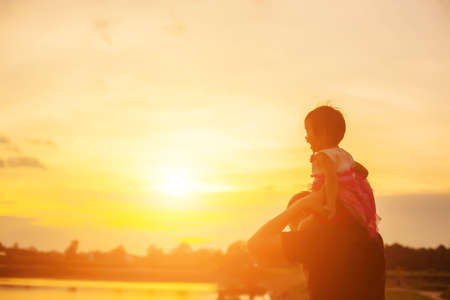 Father took the baby learn to walk at sunset.の写真素材