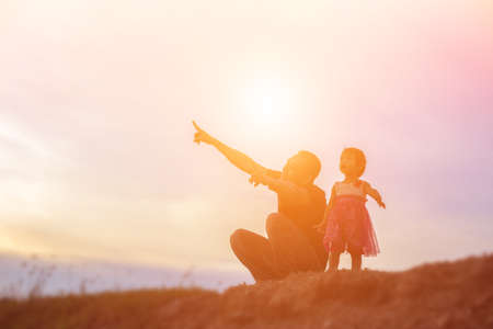 Father took the baby learn to walk at sunset.の写真素材