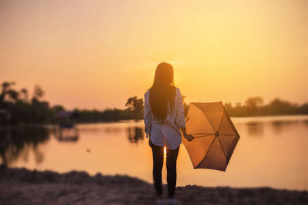 Silhouette of the beautiful girl in the nature at summer sunset.の写真素材