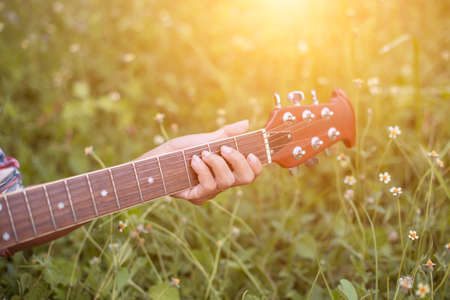 Young hipster woman playing guitar to relaxing on his holiday, enjoy with natural and fresh air.の写真素材