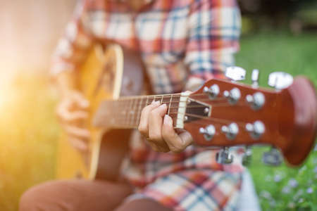 Young hipster woman playing guitar to relaxing on his holiday, enjoy with natural and fresh air.の写真素材