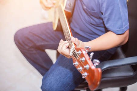 Close up man's hand playing the guitar.の写真素材