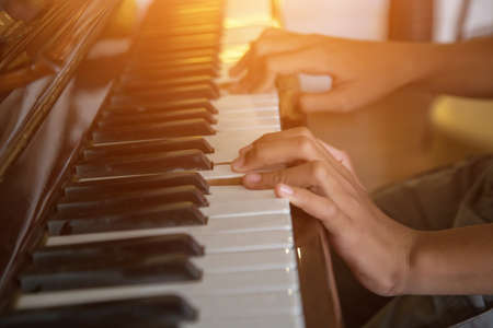 Musician playing piano with vintage filter.