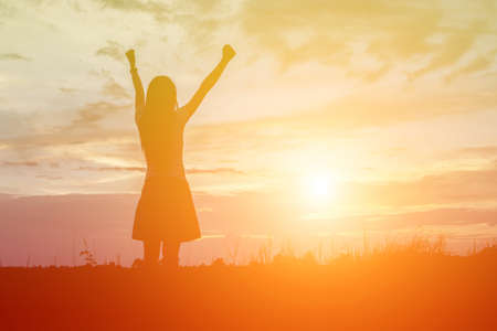 Silhouette of woman praying over beautiful sky backgroundの写真素材