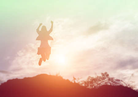 Happy woman jumping against beautiful sunset. Freedom, enjoyment concept.の写真素材