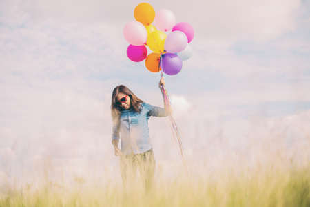 Beautiful Girl jumping with balloons on the beach