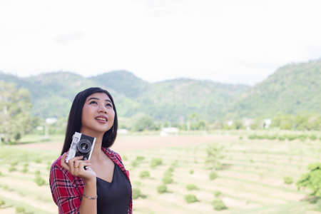 Young hipster woman photographer holding a vintage camera.