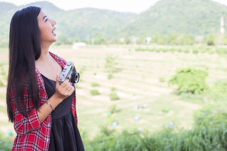 Young hipster woman photographer holding a vintage camera.の写真素材