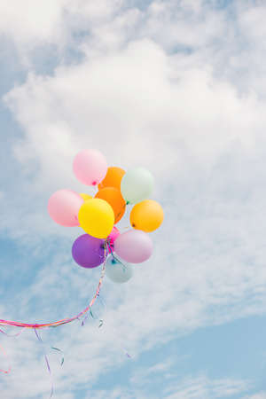 Beautiful Girl jumping with balloons on the beachの写真素材