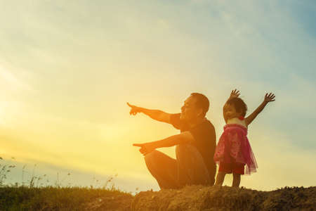 Father took the baby learn to walk at sunset.の写真素材